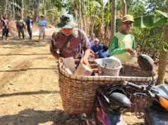 Semangat Anggota Satgas TMMD, Tetap Enjoi Mengendarai Sepeda Motor Sambil Membawa Keranjang Berisi Alat Tukang